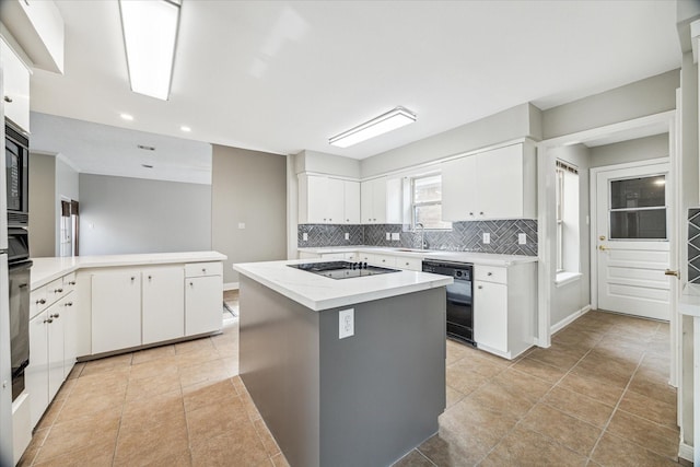 kitchen with sink, light tile patterned floors, white cabinetry, a center island, and black appliances