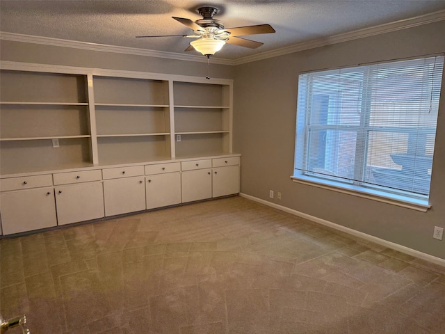 unfurnished dining area with ceiling fan, crown molding, light carpet, a textured ceiling, and built in shelves