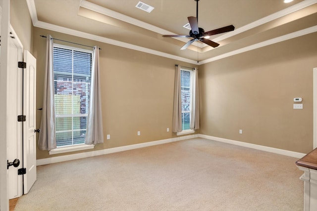 spare room featuring crown molding, light colored carpet, ceiling fan, and a tray ceiling