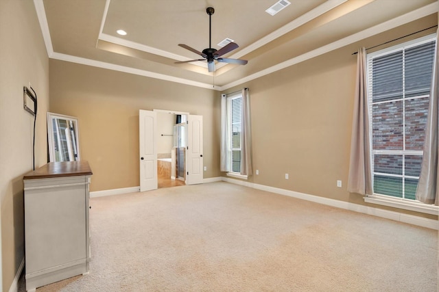 carpeted empty room with ornamental molding, ceiling fan, and a tray ceiling