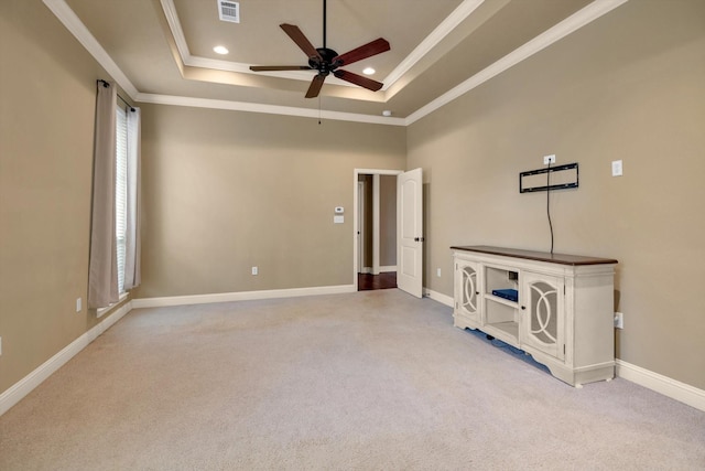 unfurnished room with crown molding, ceiling fan, a tray ceiling, and light carpet