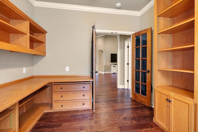 unfurnished office featuring crown molding, dark hardwood / wood-style floors, and built in desk