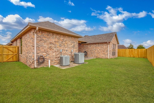 rear view of property with a patio, central AC unit, and a lawn