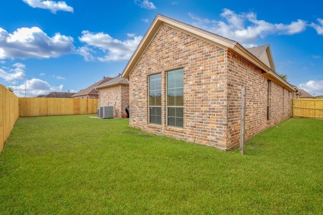 back of house featuring a yard and central AC unit