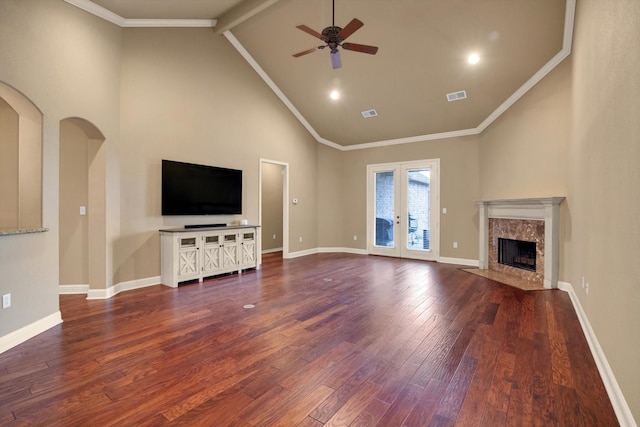 unfurnished living room with dark wood-type flooring, ceiling fan, a premium fireplace, and high vaulted ceiling