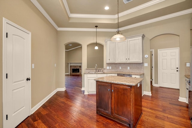 kitchen featuring white cabinetry, decorative light fixtures, and crown molding