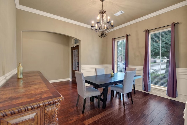 dining area with crown molding, an inviting chandelier, and dark wood-type flooring