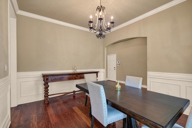 dining area with ornamental molding, dark wood-type flooring, and a chandelier