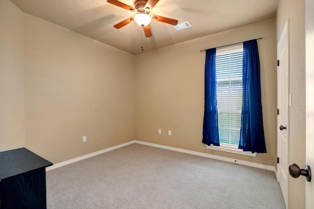 carpeted spare room with ceiling fan