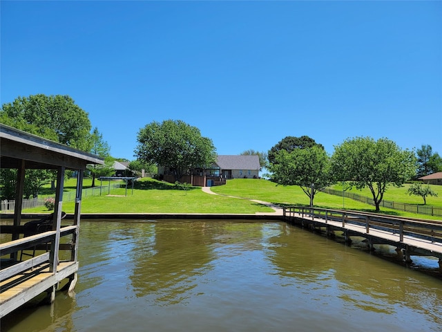 view of dock with a water view and a yard