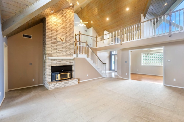 unfurnished living room with carpet flooring, wood ceiling, ceiling fan, and a high ceiling