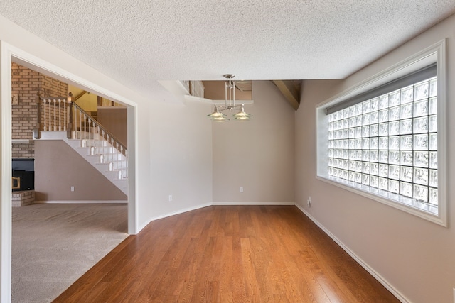 spare room featuring wood-type flooring and a textured ceiling