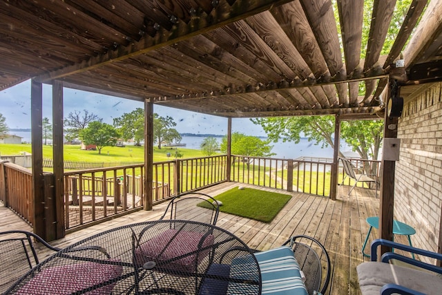 wooden terrace featuring a water view and a lawn