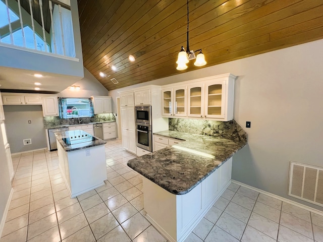 kitchen with white cabinetry, decorative backsplash, stainless steel appliances, and kitchen peninsula