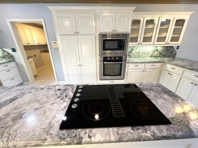 kitchen with tasteful backsplash, stainless steel appliances, and white cabinets