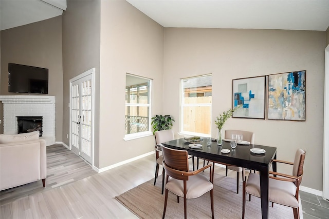 dining space with a brick fireplace and light hardwood / wood-style flooring