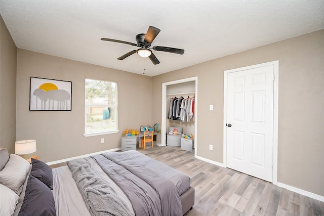 bedroom featuring a textured ceiling, ceiling fan, and light wood-type flooring