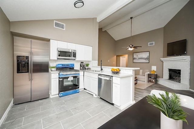 kitchen featuring sink, appliances with stainless steel finishes, backsplash, white cabinets, and kitchen peninsula