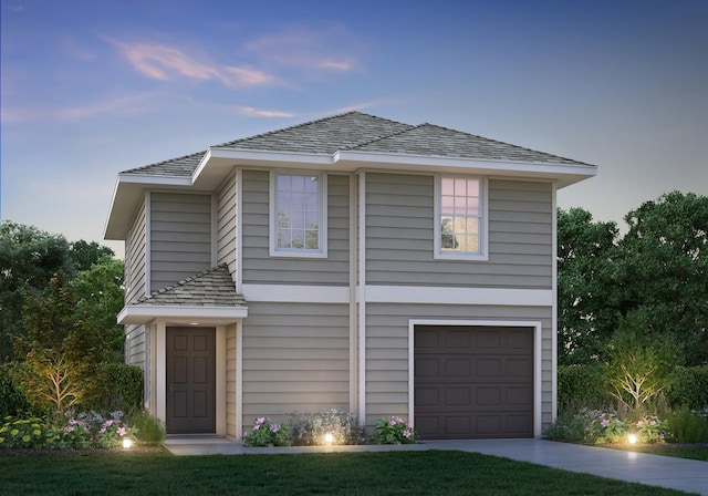 traditional-style home featuring an attached garage and driveway