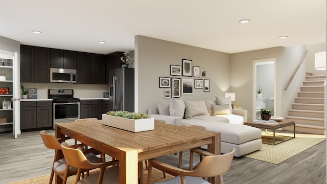 dining room featuring light wood-type flooring, stairway, and recessed lighting