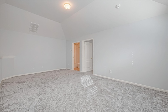 carpeted spare room featuring lofted ceiling