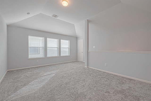 unfurnished room with lofted ceiling and light carpet