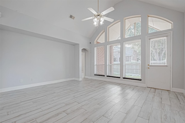 unfurnished living room featuring a wealth of natural light, ceiling fan, and light wood-type flooring