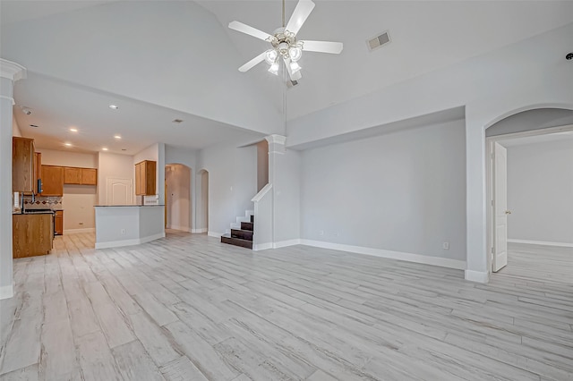 unfurnished living room featuring ceiling fan, high vaulted ceiling, and light hardwood / wood-style flooring