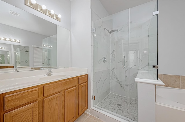 bathroom featuring walk in shower, vanity, and tile patterned flooring