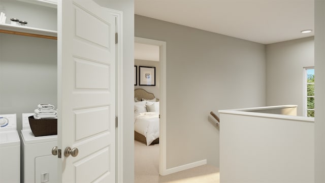 hallway with carpet floors, independent washer and dryer, an upstairs landing, and baseboards