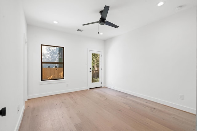 empty room with ceiling fan and light hardwood / wood-style flooring