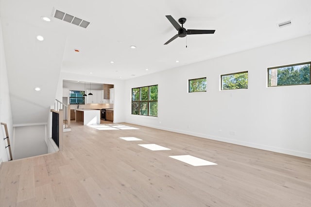 unfurnished living room with ceiling fan and light hardwood / wood-style floors