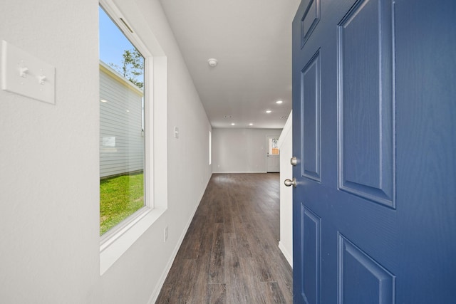 corridor with dark wood-type flooring, recessed lighting, and baseboards