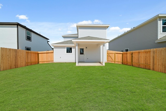 back of house with a patio area, a fenced backyard, and a lawn