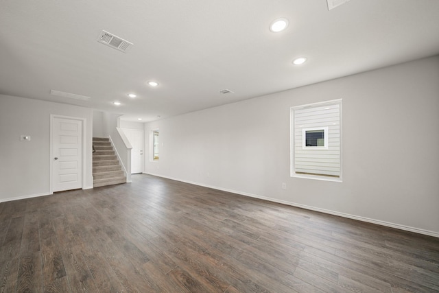 unfurnished room with dark wood-style floors, stairs, visible vents, and recessed lighting