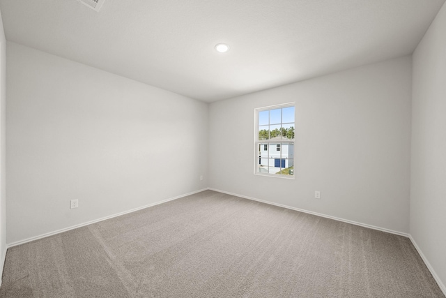 carpeted spare room featuring baseboards