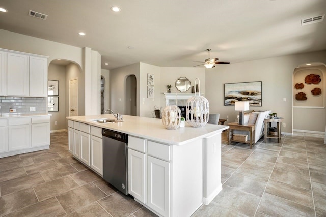 kitchen with white cabinetry, stainless steel dishwasher, a kitchen island with sink, and sink