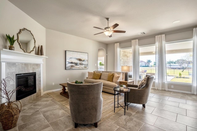 living room with ceiling fan, a fireplace, and a healthy amount of sunlight