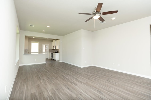 unfurnished living room featuring ceiling fan and light hardwood / wood-style floors