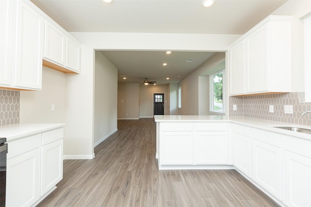 kitchen with white cabinetry, sink, and light hardwood / wood-style flooring