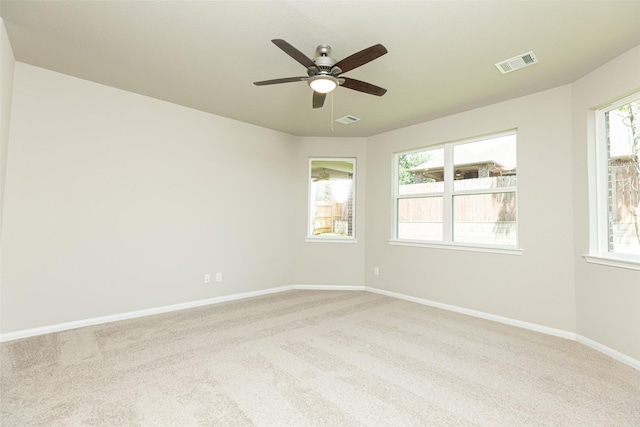 carpeted spare room with a healthy amount of sunlight and ceiling fan