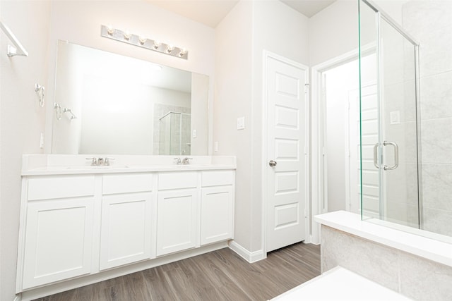 bathroom featuring hardwood / wood-style flooring, vanity, and walk in shower