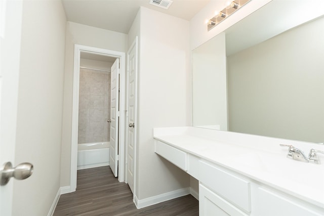 bathroom featuring vanity, hardwood / wood-style flooring, and tiled shower / bath