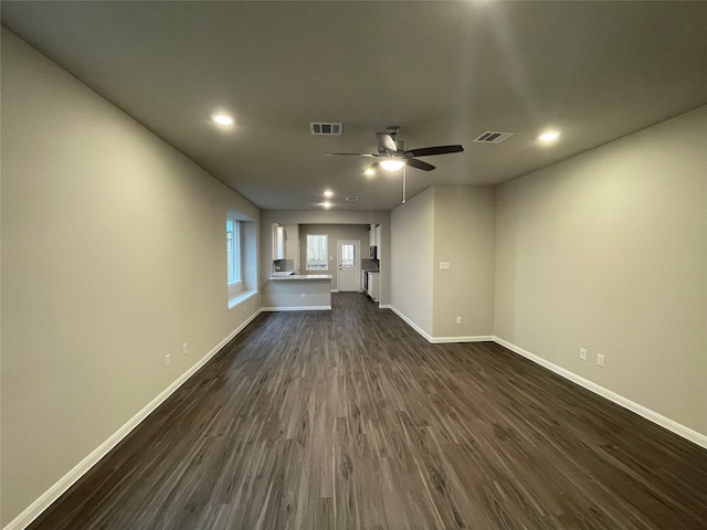 unfurnished living room featuring dark hardwood / wood-style flooring and ceiling fan