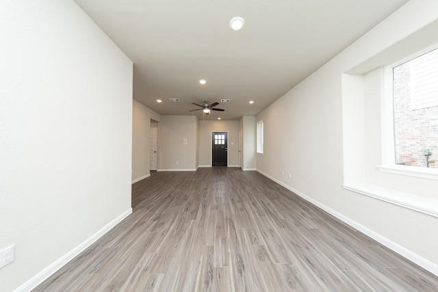 interior space featuring light wood finished floors, ceiling fan, baseboards, and recessed lighting