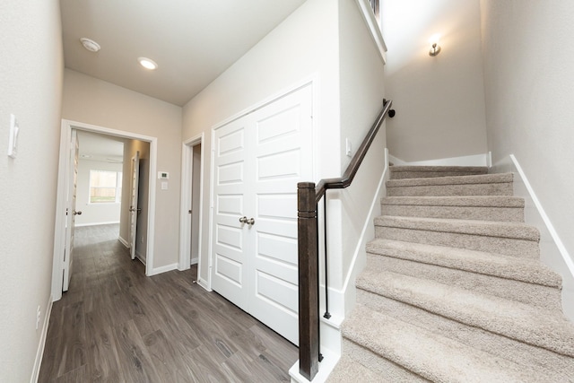 stairway featuring baseboards, wood finished floors, and recessed lighting