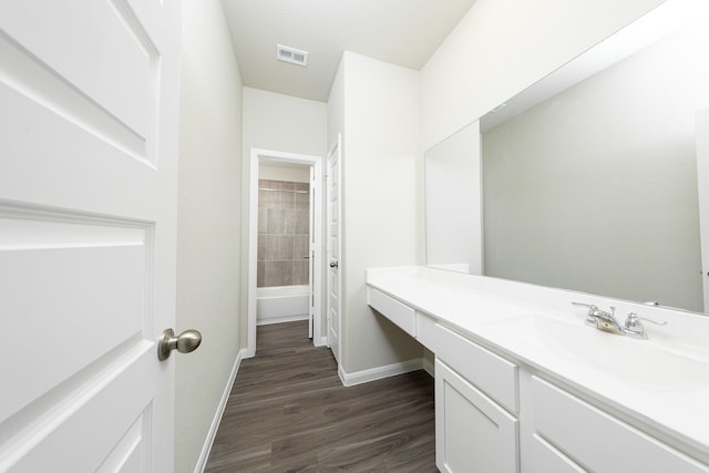 full bathroom featuring visible vents, vanity, baseboards, and wood finished floors