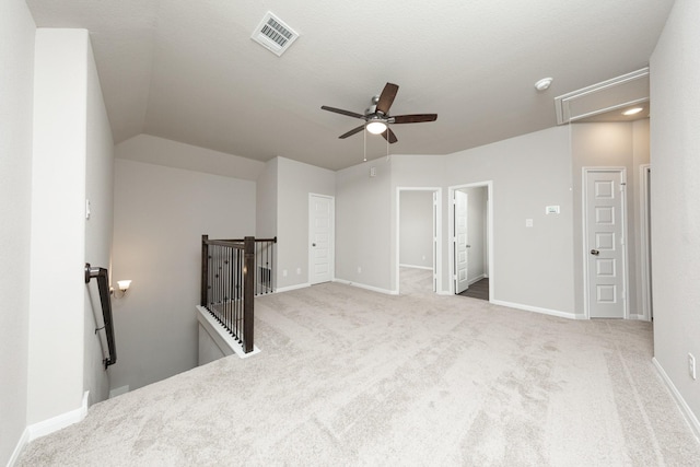 interior space featuring visible vents, attic access, a ceiling fan, carpet flooring, and baseboards