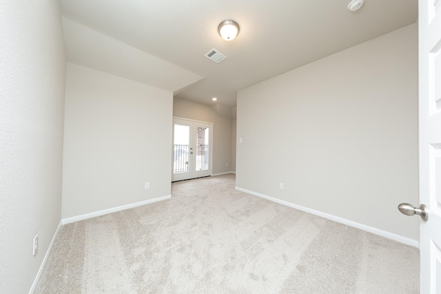 empty room with light colored carpet, visible vents, and baseboards