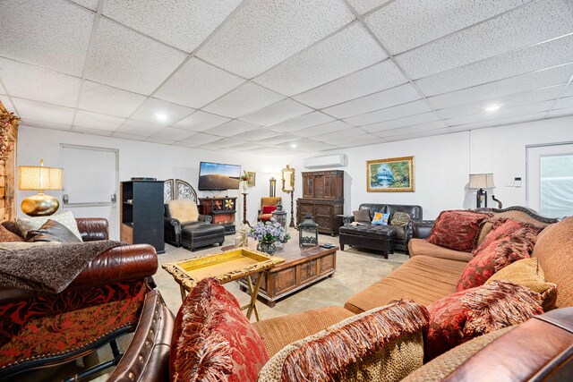 living room featuring a paneled ceiling and an AC wall unit